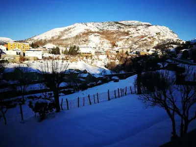 a snow covered mountain in front of a city at Villa Sabina 