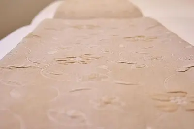 a beige cloth with white flowers on it at Casa Teodora by Adeloló in Arzúa
