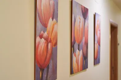 a row of paintings of flowers on a wall at Casa Teodora by Adeloló in Arzúa