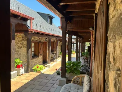 an outside view of a building with a patio at Alojamientos Rurales El Fontano in Galende