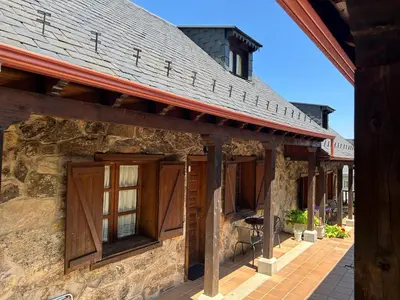 a building with wooden doors and windows on it at Alojamientos Rurales El Fontano in Galende