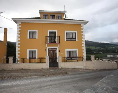 a yellow house on the side of a road at Casa Rubieira in Sequeiro