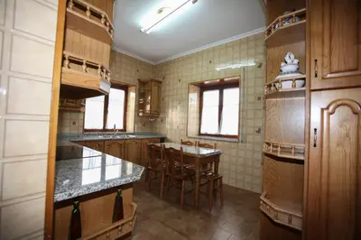 a kitchen with wooden cabinets and a table and chairs at Casa Rubieira in Sequeiro