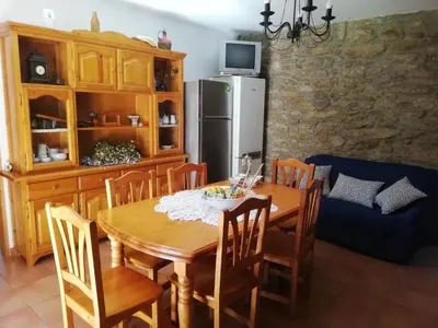 a kitchen with a wooden table with chairs and a refrigerator at Casa Da Pallota in Moraña