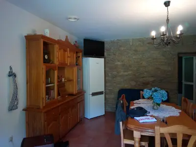 a kitchen with a table and a white refrigerator at Casa Da Pallota in Moraña