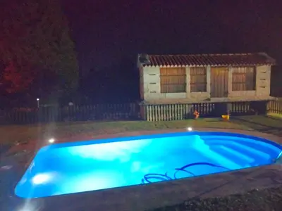 a swimming pool in front of a house at night at Casa Da Pallota in Moraña