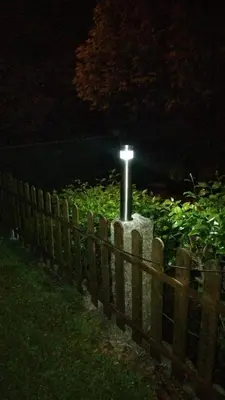 a cross in a garden behind a fence at night at Casa Da Pallota in Moraña
