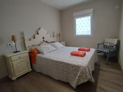 a bedroom with a bed with two red pillows on it at San Pedro in Cangas de Foz
