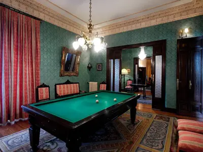 a living room with a pool table and a chandelier at Palacio Arias in Navia