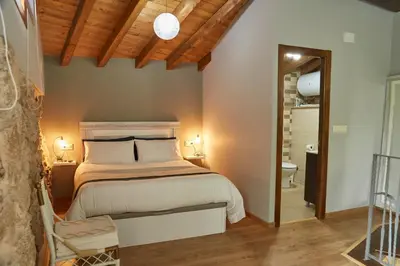a bedroom with a king sized bed and a bathroom at A Cucada in Sabariz