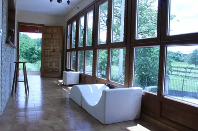 a living room with large windows and a white couch at Casa do Bouza Vello in Sober