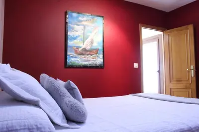 a bedroom with a bed with a painting on the wall at Casa do Bouza Vello in Sober