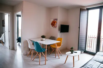 a living room with a table and chairs and a couch at O balcón da ribeira in Parada del Sil
