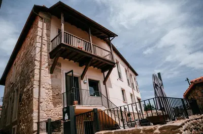 an old house with a balcony on the side of it at O balcón da ribeira in Parada del Sil