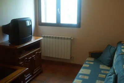 a room with a tv and a bed and a window at Hotel Rural El Rincón de Trefacio in Trefacio
