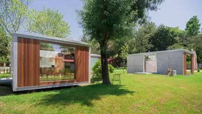 a small house in a field with a tree at Bungalow Camping Los Manzanos in Santa Cruz de Oleiros