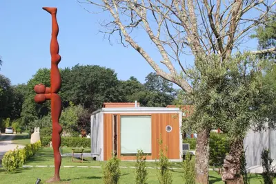 a sculpture of a woman standing next to a building at Bungalow Camping Los Manzanos in Santa Cruz de Oleiros