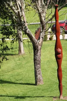 a statue of a fire hydrant next to a tree at Bungalow Camping Los Manzanos in Santa Cruz de Oleiros
