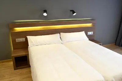 a bed with a wooden headboard and two pillows at Hotel Alda Sada Marina in Sada