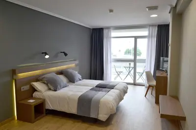 a bedroom with a large bed and a balcony at Hotel Alda Sada Marina in Sada