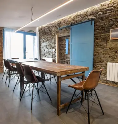 a dining room with a wooden table and chairs at Montebreamo in Puentedeume