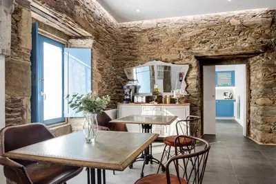 a kitchen with two tables and chairs in a room at Montebreamo in Puentedeume