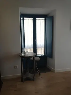 a table and a chair in a room with windows at Montebreamo in Puentedeume