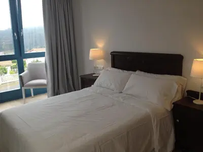 a bedroom with a bed and a chair and a window at Montebreamo in Puentedeume