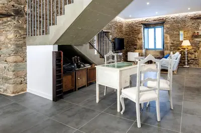 a kitchen with a table and chairs and a staircase at Montebreamo in Puentedeume
