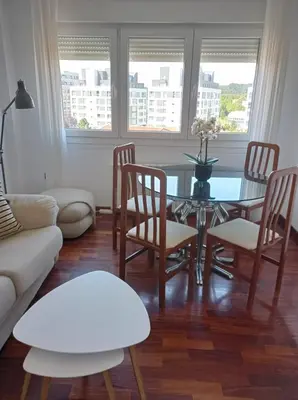 a living room with a glass table and chairs at Apartamento Santa Marta in Santiago de Compostela