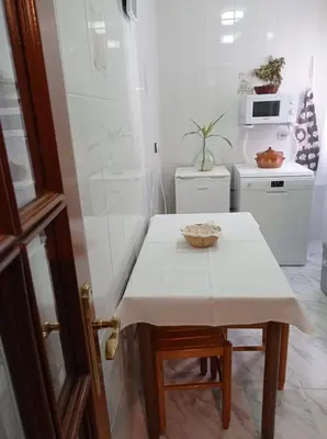 a small kitchen with a white table with a bowl on it at Apartamento Santa Marta in Santiago de Compostela