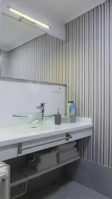 a bathroom with a sink and a large mirror at RyS Ourense Centro PARKING Gratis in Ourense