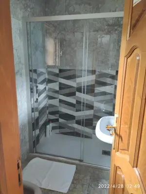 a bathroom with a glass shower with a sink at Albergueria Frade in O Cebreiro