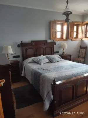 a bedroom with a large wooden bed and two lamps at Albergueria Frade in O Cebreiro