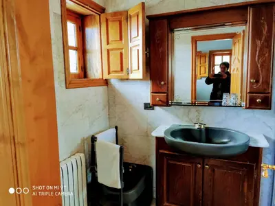 a person taking a picture of a bathroom sink at Albergueria Frade in O Cebreiro