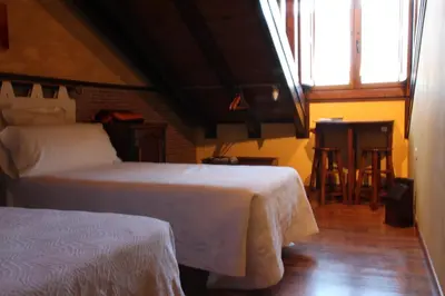 a bedroom with a green bed with white pillows at Micro-Hostal La Puerta del Perdón in Villafranca del Bierzo