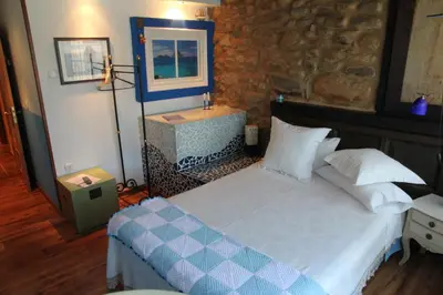 a bedroom with two beds and a table and chairs at Micro-Hostal La Puerta del Perdón in Villafranca del Bierzo