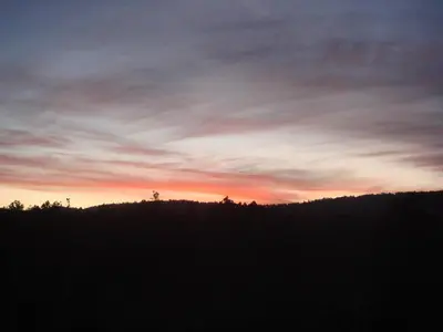 a sunset over a field with trees in the foreground at Apartamento Good Way in O Pedrouzo