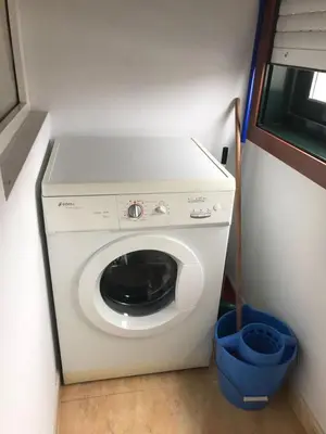 a washing machine in a room with a blue bucket at Apartamento Good Way in O Pedrouzo