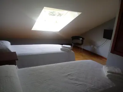 a room with two beds and a skylight at Apartamento Good Way in O Pedrouzo
