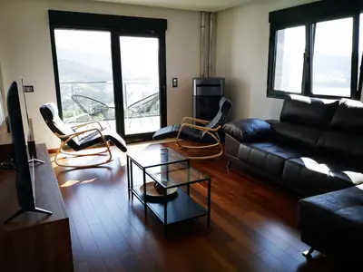 a living room with a black couch and chairs at Alojamientos Viveiro - El Escairo in Viveiro