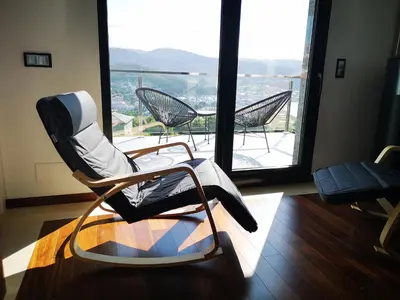 a room with chairs and a balcony with a view at Alojamientos Viveiro - El Escairo in Viveiro