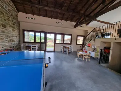 a large room with a ping pong table in the middle at Aldea Rural A Cortiña in Pepín