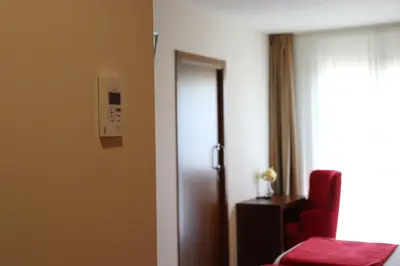 a hotel room with two beds and a chair at HOTEL ARZÚA in Arzúa