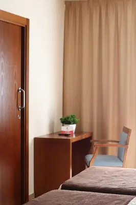 a cat sitting on a bed in a hotel room at HOTEL ARZÚA in Arzúa