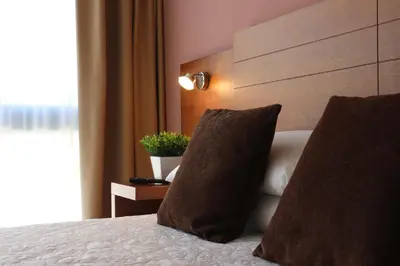 a bedroom with a large bed with a wooden headboard at HOTEL ARZÚA in Arzúa