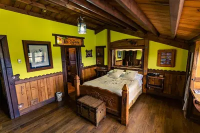 a bedroom with a bed and yellow walls and wooden floors at Prada a Tope - Palacio de Canedo in Canedo