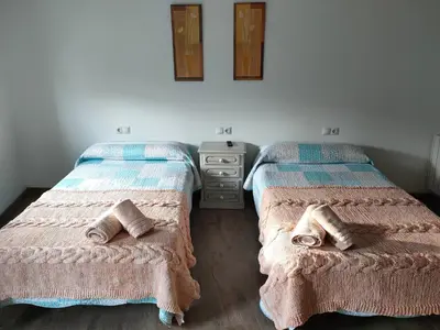 two beds sitting next to each other in a room at A Casa das Burgas in Cuntis