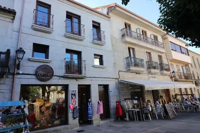 a store with tables and chairs in front of a building at A Casa das Burgas in Cuntis