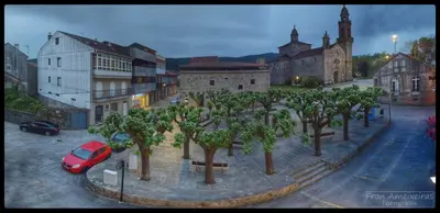 a street with trees and a red car in a city at A Casa das Burgas in Cuntis